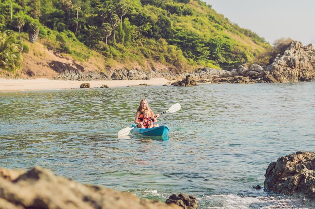 Mother and son kayaking at tropical ocean.