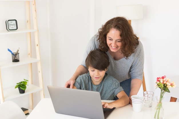 Photo mother and son looking on laptop