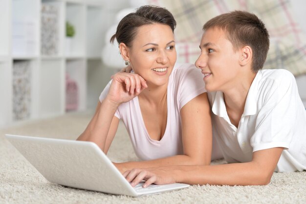 Mother and son lying on floor and using tablet