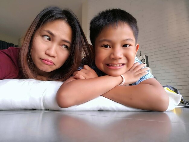 Photo mother and son lying on mattress at home