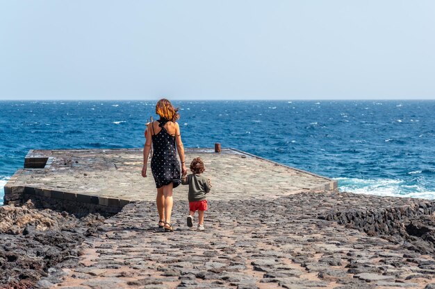 Mother and son at the pier in Orchilla on the southwest coast of El Hierro Canary Islands