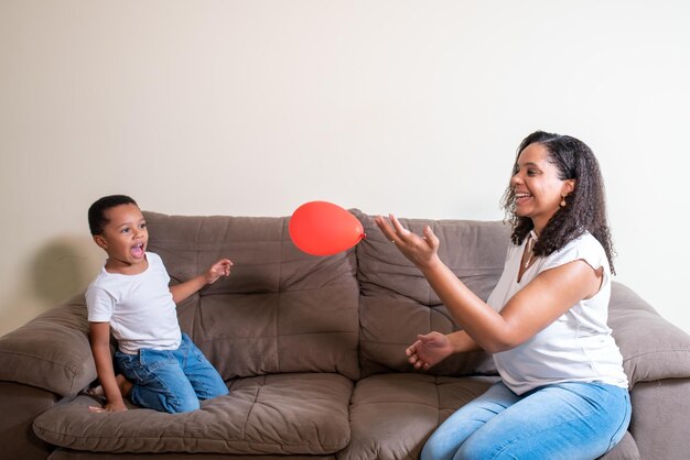 Мать и сын играют на воздушном шаре в день матери
