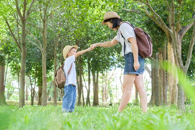 A mother and son playing in grass fields outdoors