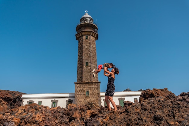 Mother and son playing having fun in the beautiful lighthouse of Orchilla in southwest El Hierro Canary Islands
