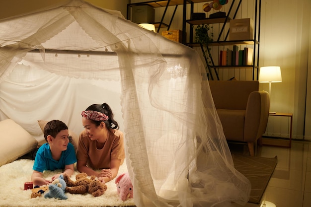 Photo mother and son playing inside tent