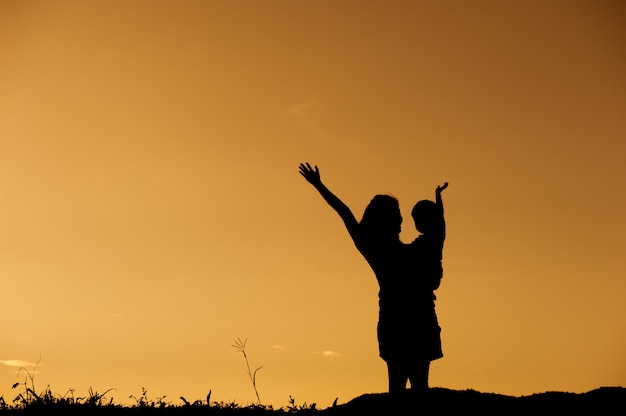 Una madre e un figlio che giocano all'aperto al tramonto