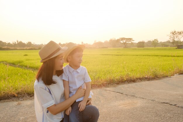 A mother and son playing outdoors at sunset 