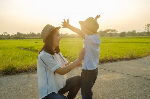 A mother and son playing outdoors at sunset 