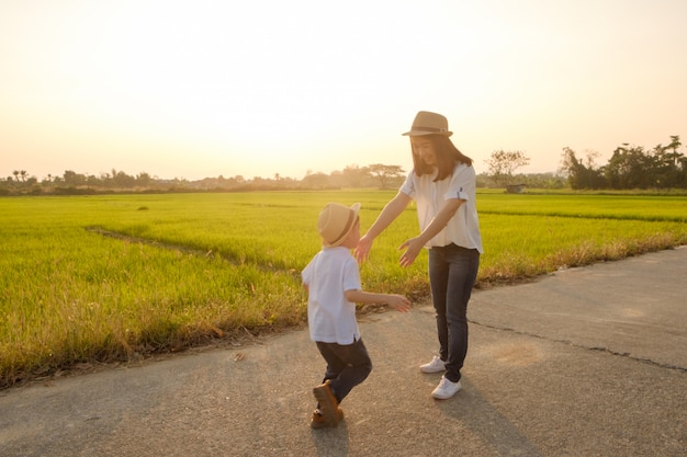 Photo a mother and son playing outdoors at sunset