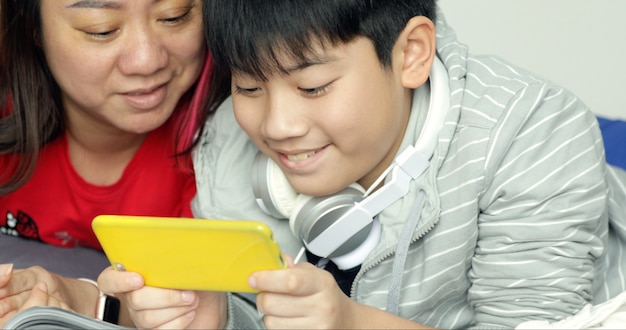 Mother and son playing with a smartphone together.