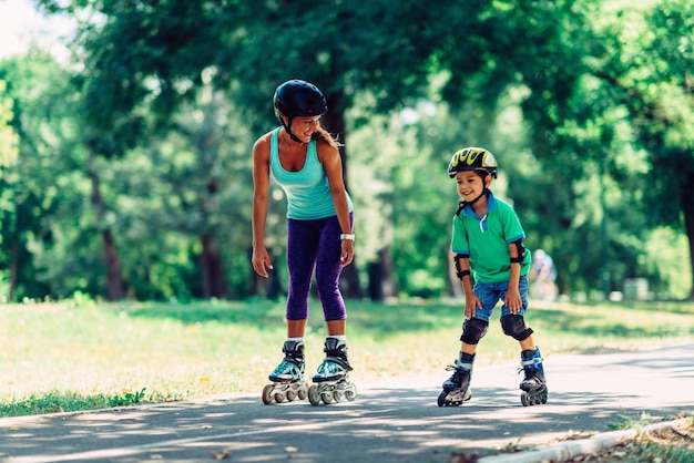 Mother and son roller skating in park