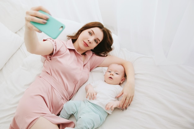 Mother and son selfie in the bedroom. Top view. Copy space