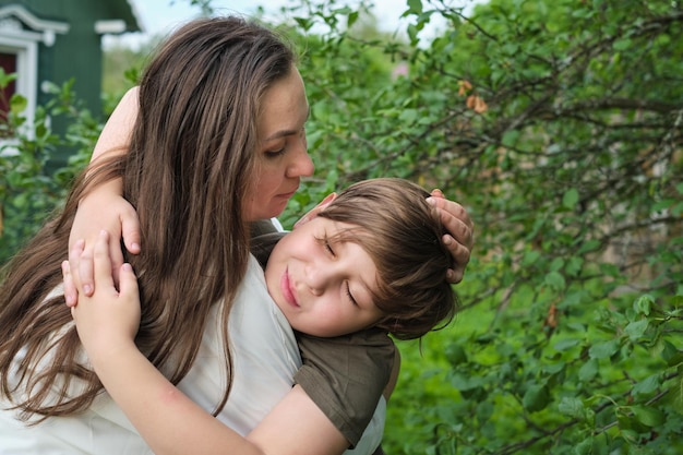 A mother and son share a joyous moment in a lush park embodying the essence of authentic family