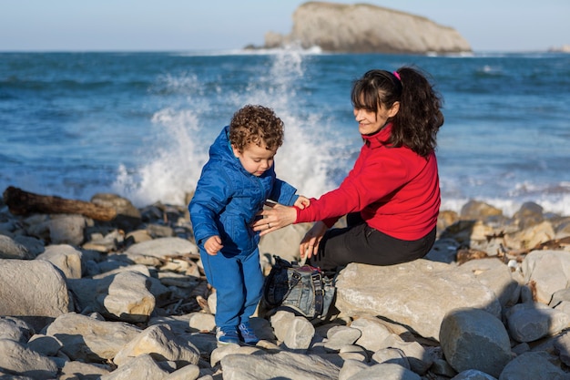 Mother and son spending the afternoon on the rocks by the sea