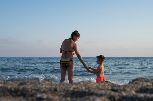 Mother son spending time together sea vacation. Family with one child. Happy childhood with mommy.