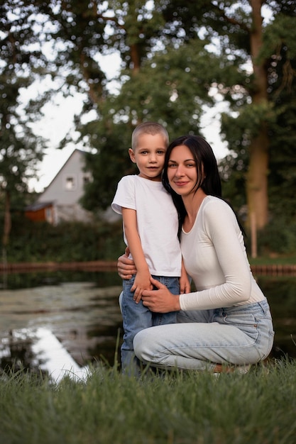 Mother and son in the summer in nature near the lake A family day with a hug