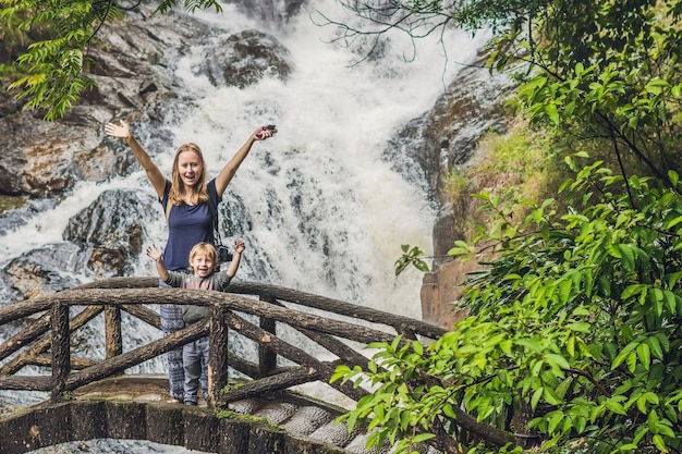 Mother and son in the surface of beautiful cascading Datanla waterfall In the mountain town Dalat, Vietnam