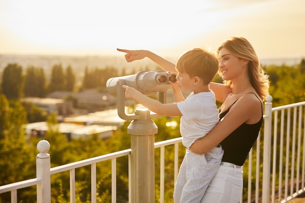 Mother and son using binoculars on viewpoint