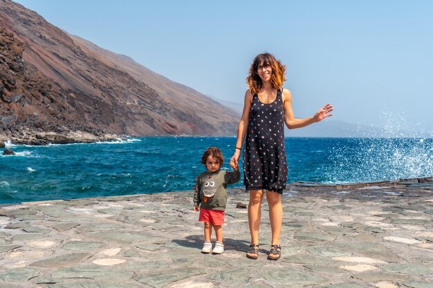 Mother and son on vacation in summer at the pier of Orchilla on the southwest coast of El Hierro Canary Islands