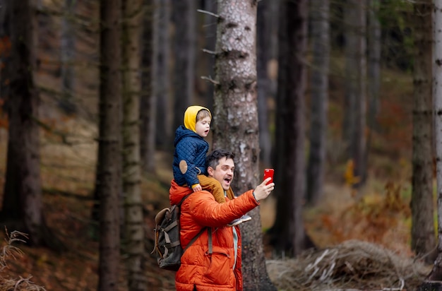 Mother and son walk through the forest in autumn