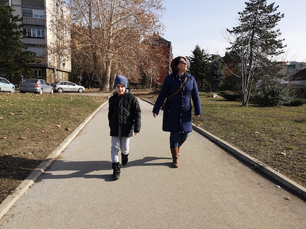 Photo mother and son walking in city