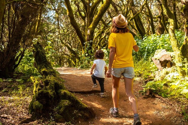 Mother and son walking in La Llania on El Hierro Canary Islands On a path of laurel from El Hierro in a lush green landscape