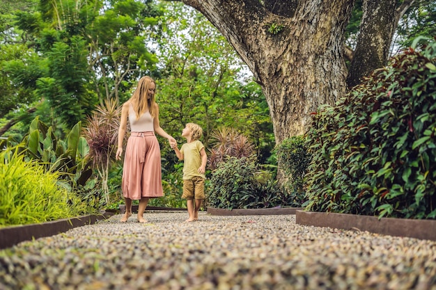 Mother and son walking on a textured cobble pavement,\
reflexology. pebble stones on the pavement for foot\
reflexology