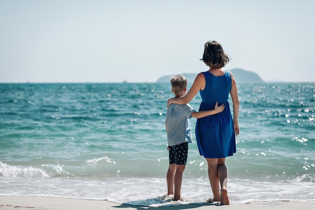 엄마와 아들은 함께 바다를 봅니다. 엄마는 아이의 손을 잡고 있습니다. 뒷모습. 여름 바다 휴가 개념입니다. 푸켓. 태국