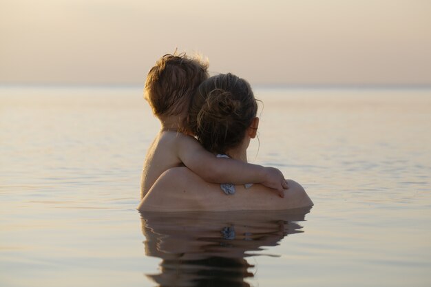 Photo mother and son watching the sunset