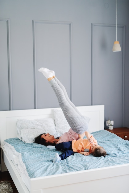 Foto madre e figlio che lavorano sul letto prima di coricarsi. interno camera da letto.