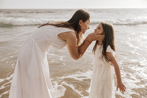 mother speaking with daughter near sea