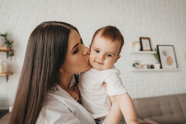 A mother spends time with her beautiful child holding him in her arms and hugging him tenderly Concept of motherhood and happy childhood