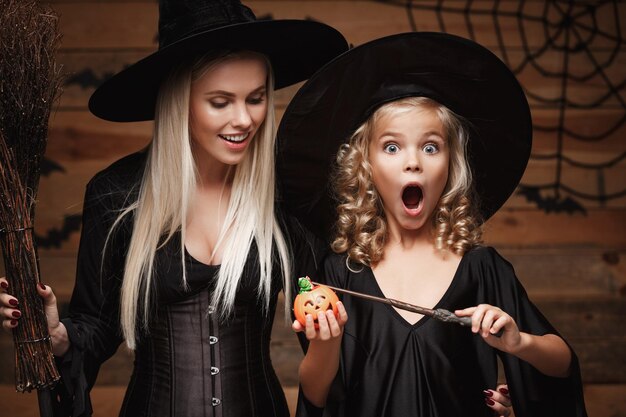 Photo mother and surprises daughter wearing halloween costume