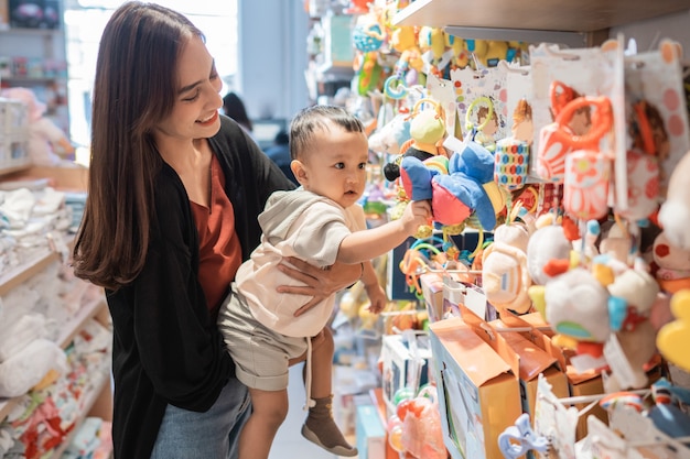 母はおもちゃを買うために彼女の歳の息子を連れて行きます