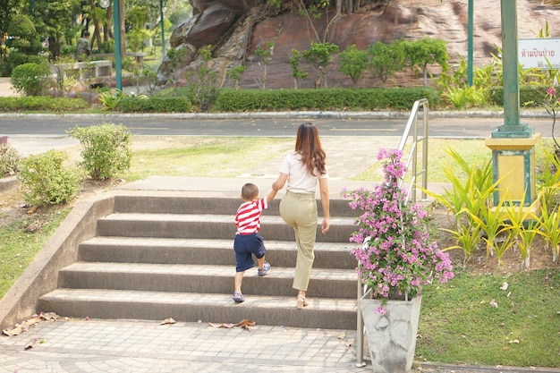 Мать берет ребенка на прогулку в парке отдыха