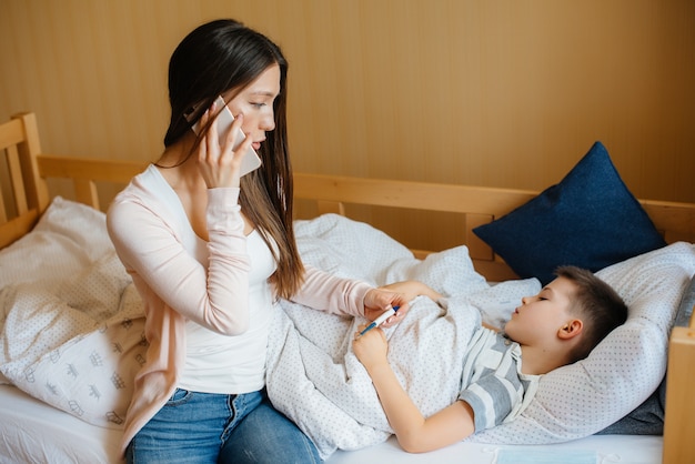 A mother takes care of her child who has a fever and fever. Covid19, coronavirus, pandemic.