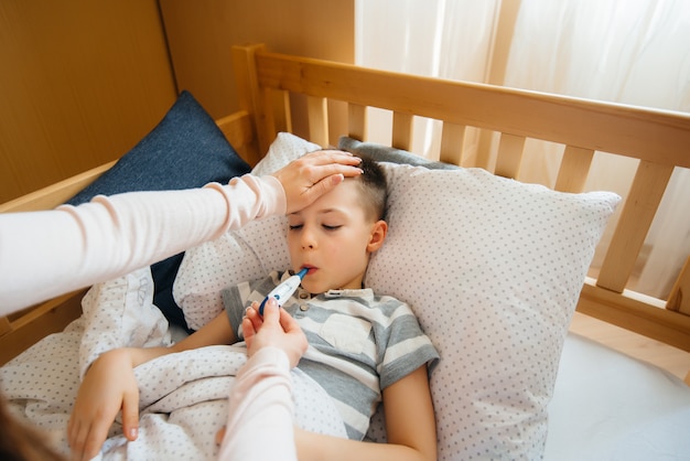 Foto una madre si prende cura di suo figlio che ha la febbre e la febbre.