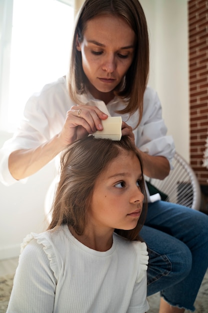 Foto madre che si prende cura di suo figlio con i pidocchi