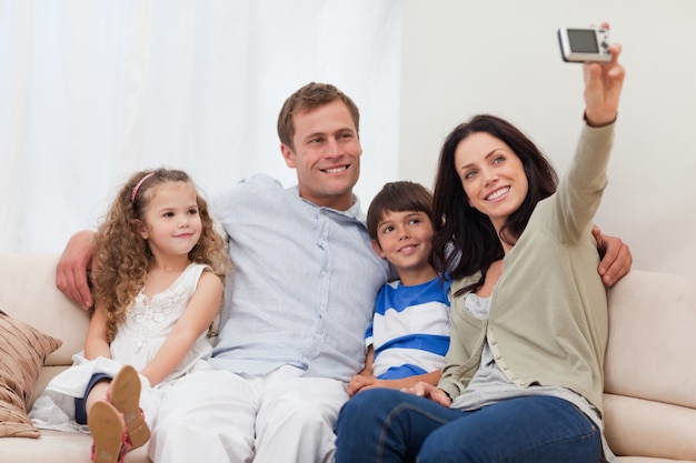 Mother taking a family picture on the sofa