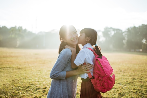 朝、娘を学校に連れて行く母親