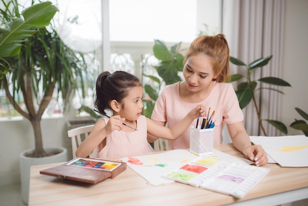 Mother teaches her child how to draw