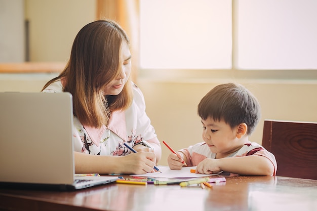 Mother teaching her son to doing homework Concept for homeschool learning and education