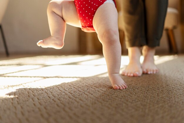 mother teaching to walk her child at home Happy family together First step baby development concept