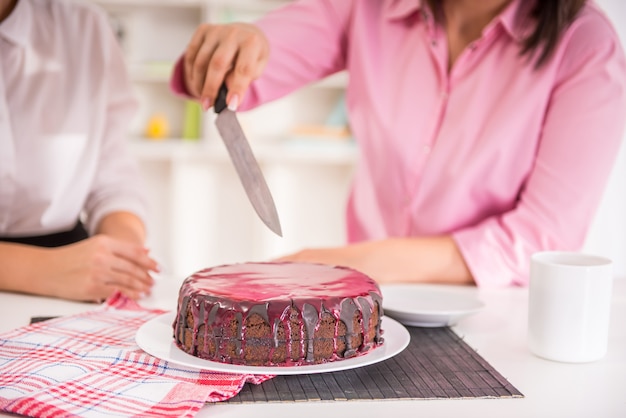 母と10代の娘が自宅でデザートを食べる