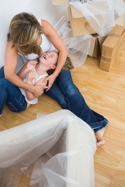 Mother tickling her daughter