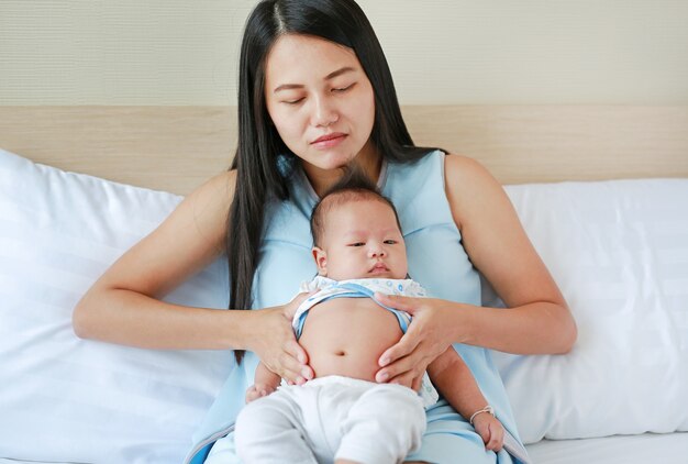 母は鼓腸に触れ、幼児を世話する。