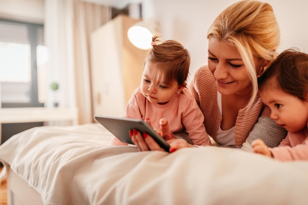 Mother and two baby girls looking at a tablet