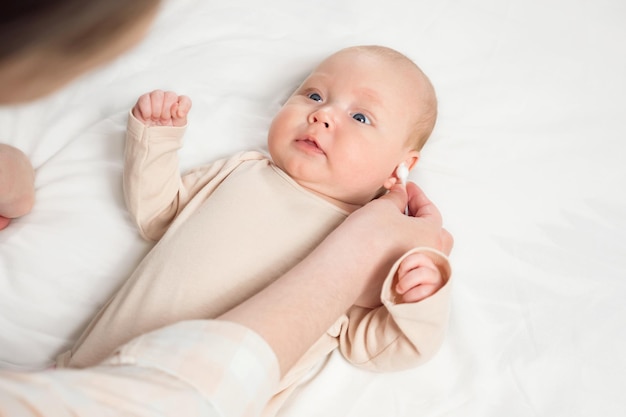 Mother use cotton bud to clean baby ear