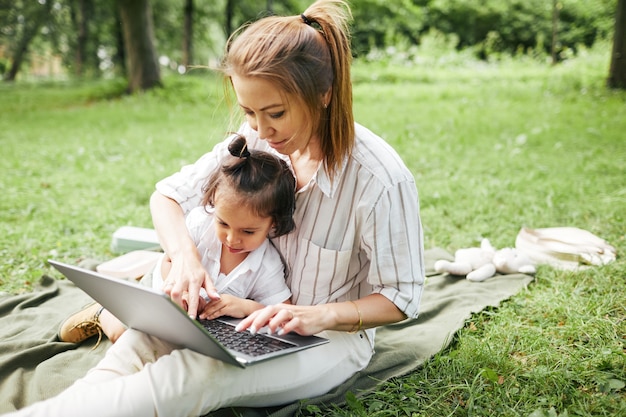 Mother using Laptop in Park