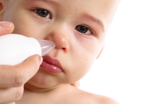 Mother using nasal aspirator on her child nose